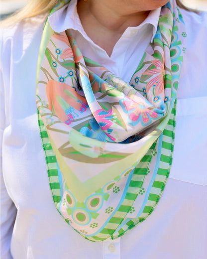 Colorful patterned scarf worn by a person on a white background