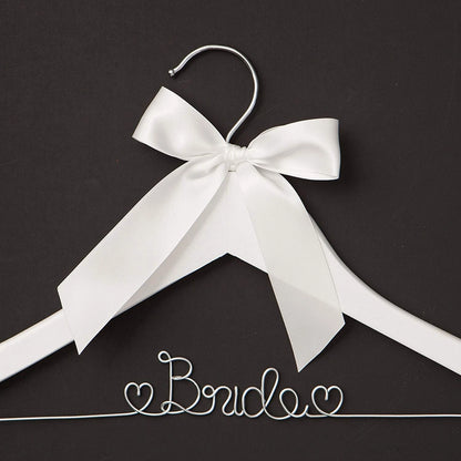 White hanger with a large white bow on a black background