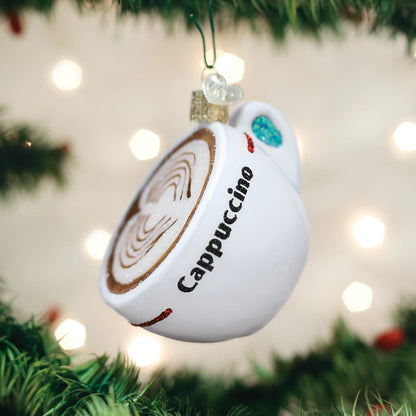 Cappuccino-themed Christmas ornament hanging on a tree with blurred lights in the background