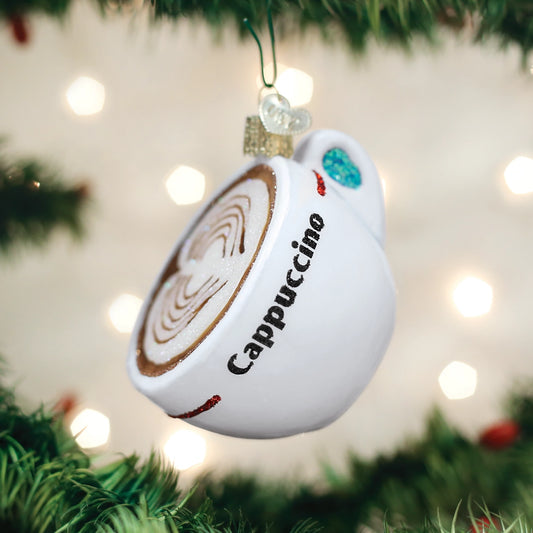 Cappuccino-themed Christmas ornament hanging on a tree with blurred lights in the background