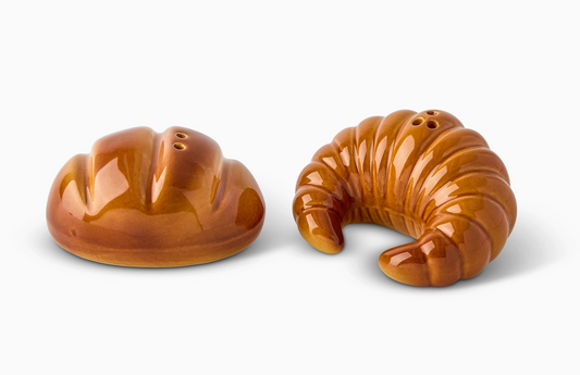 Two glossy golden-brown ceramic salt and pepper shakers shaped like French pastries and croissants