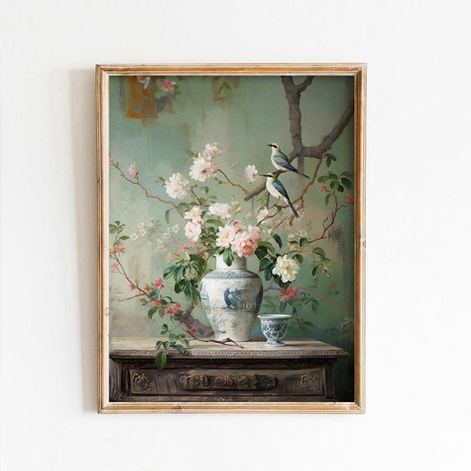 Framed painting of birds and flowers on a table with a vase.