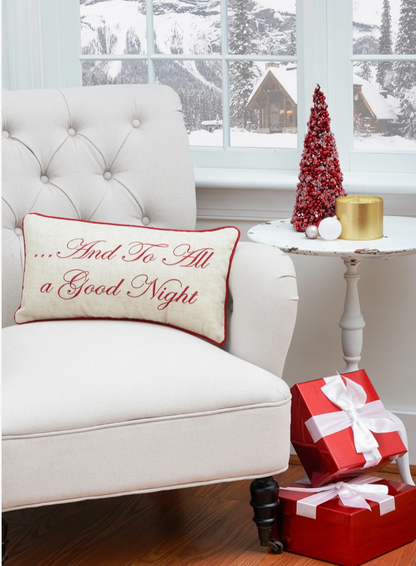 Natural linen-blend rectangular Christmas throw pillow embroidered with the words And To All a Good Night in elegant crimson red script, finished with coordinating red piping.
