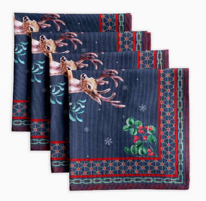 Set of four decorative napkins with deer and holly design on a blue background