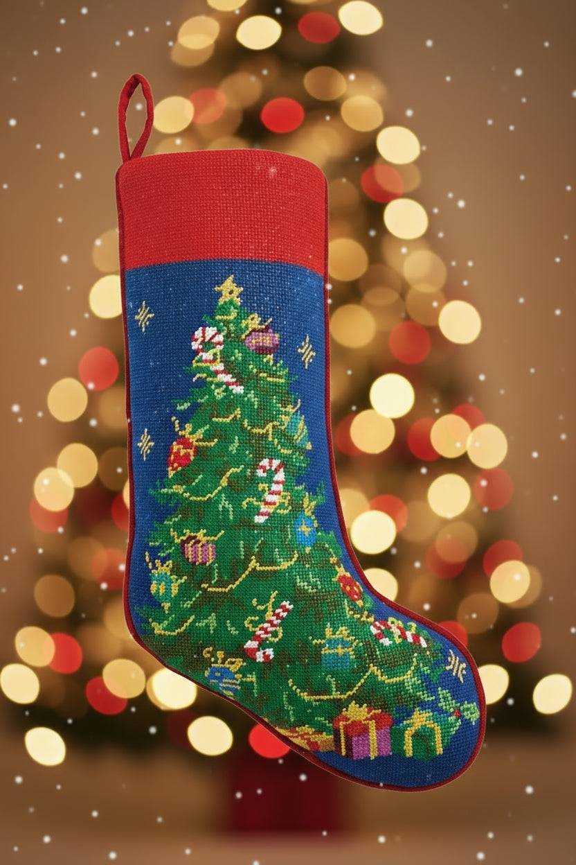 Christmas stocking with a embroidered design of a Christmas tree and presents on a blue background.