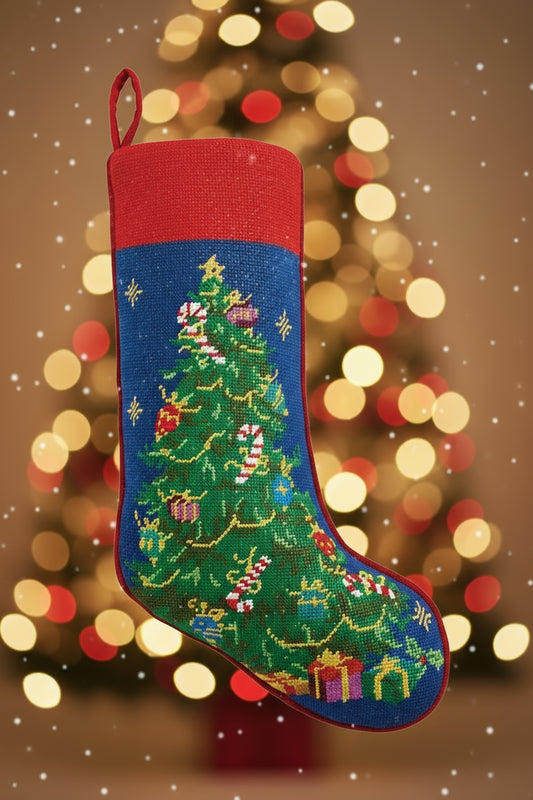 Christmas stocking with a embroidered design of a Christmas tree and presents on a blue background.