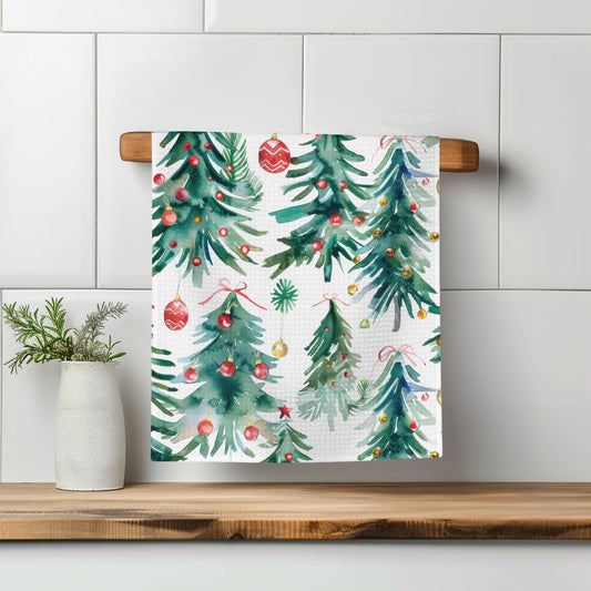 Decorative towel with Christmas tree pattern on a wooden towel rack against a tiled wall.