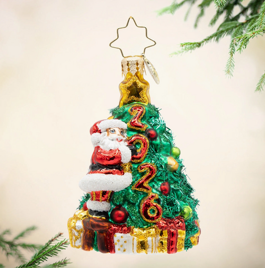 Christopher Radko Santa's 2026 Tree Trim Gem glass ornament with Santa decorating Christmas tree