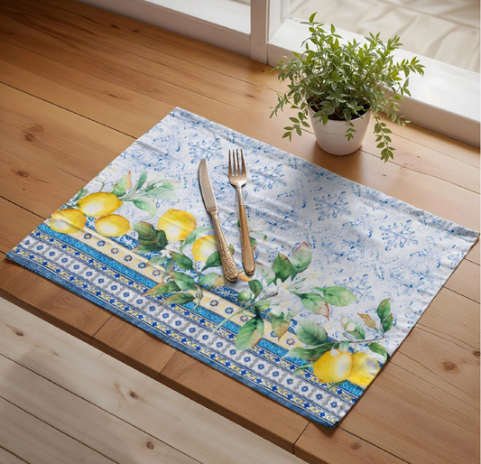 Decorative placemat with lemon design on a wooden table with cutlery and a plant.