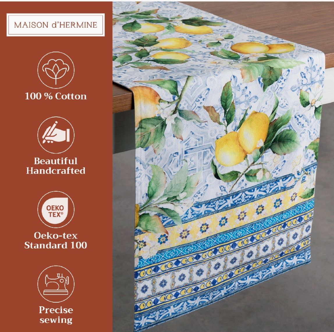 Tablecloth with lemon design on a wooden table, featuring branding and certification details.