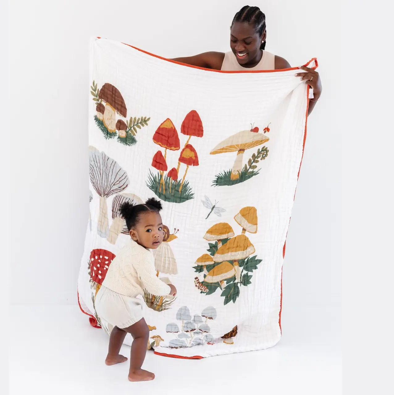 Woman and child with a mushroom-themed towel on a white background