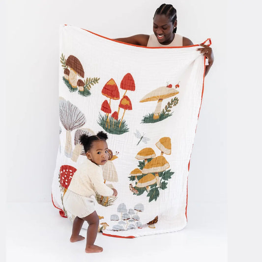 Woman and child with a mushroom-themed towel on a white background