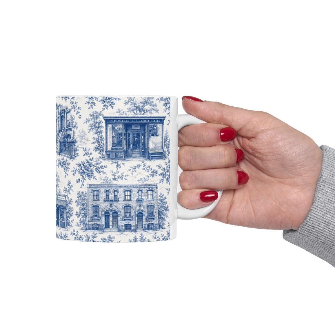 Hand holding a mug with blue and white pattern on a white background