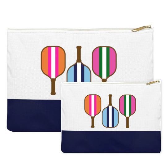 Two white zippered pouches with navy blue bottom panels, each printed with three retro paddle graphics in pink, orange, blue, green, and brown. The larger pouch is behind the smaller one on a white background. NY Gift Boutique