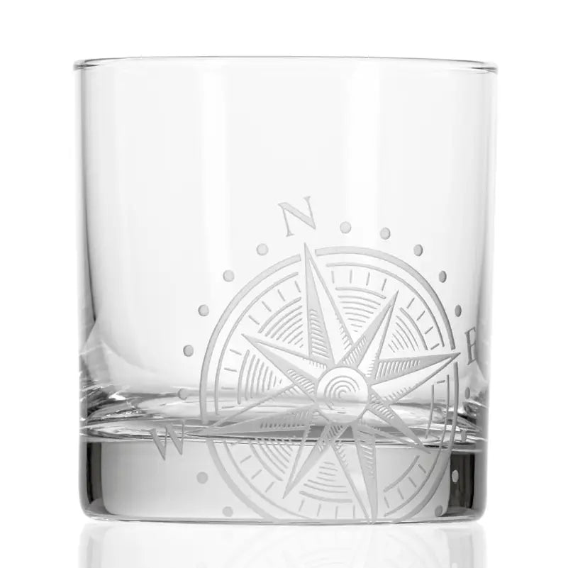 Clear glass tumbler with a compass rose engraving on a white background