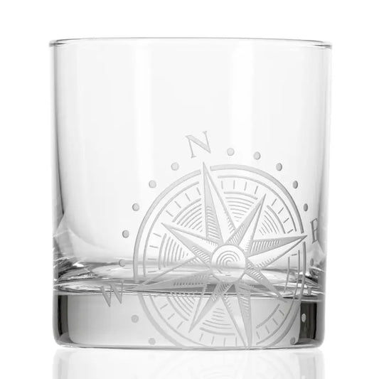 Clear glass tumbler with a compass rose engraving on a white background