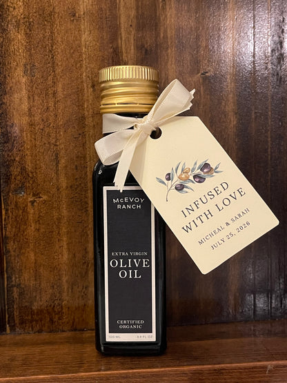 Bottle of olive oil with a personalized tag on a wooden surface