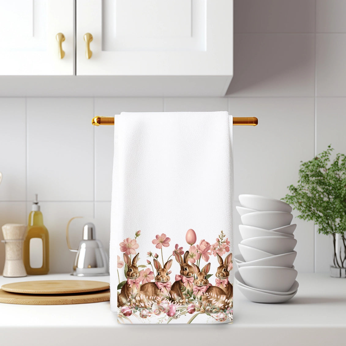 Kitchen towel with bunny and floral design hanging on a rack in a kitchen.
