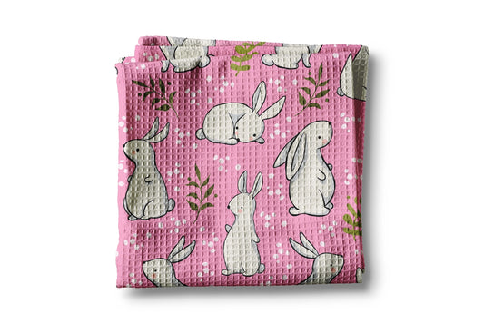 Folded pink fabric with bunny pattern on a white background