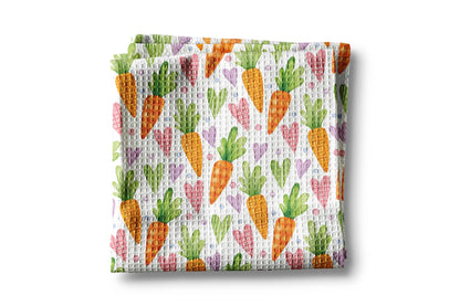 Waffle texture kitchen towel with colorful carrot pattern on a white background