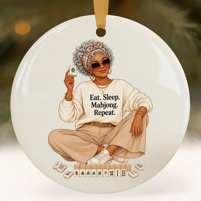Eat Sleep Mahjong Repeat ceramic ornament featuring stylish silver-haired woman holding a Mahjong tile with game tiles at her feet.