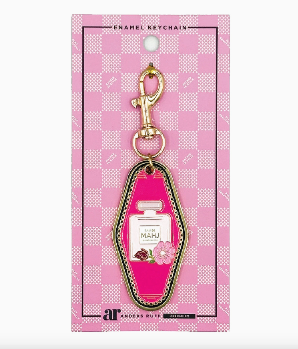 Eau De Mahj pink enamel Mahjong keychain charm by Anders Ruff featuring a perfume bottle design with floral accents and gold-tone hardware.