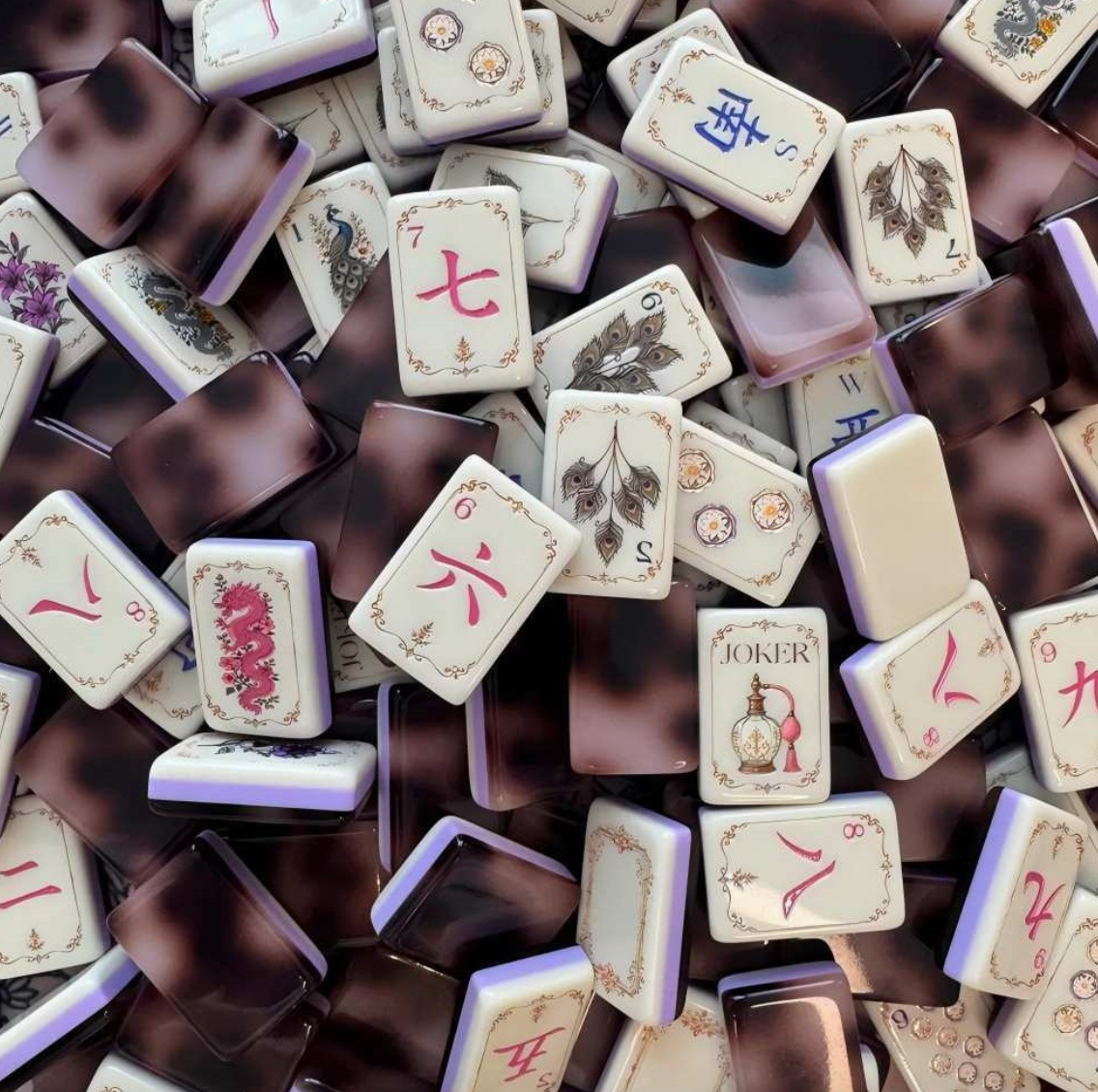 Close-up of three-layer acrylic Mahjong tiles with tortoiseshell backs, ivory faces and vintage-inspired artwork