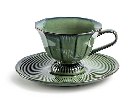 Green ceramic teacup and saucer on a white background