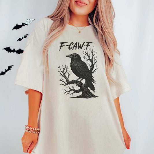Person wearing a white t-shirt with a black crow design and 'F-CAW-F' text on a light gray background.