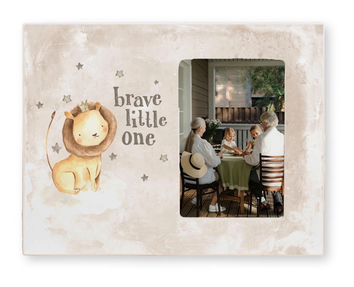 Decorative photo frame with a lion illustration and 'brave little one' text, featuring a family at a table.