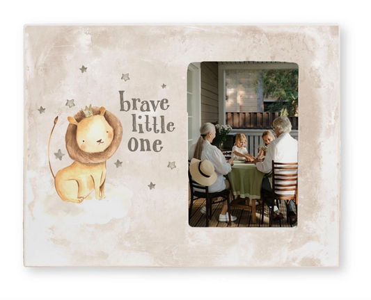Decorative photo frame with a lion illustration and 'brave little one' text, featuring a family at a table.