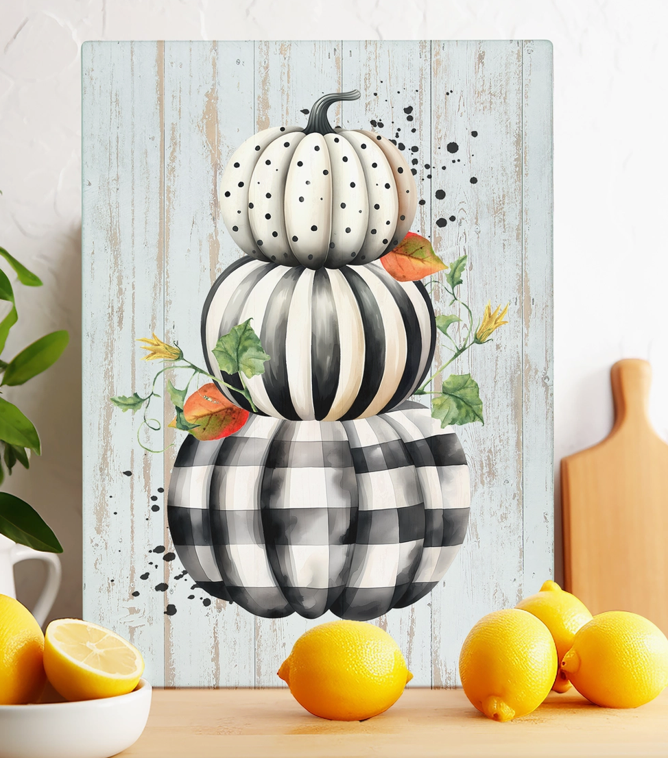 Fall black and white glass trivet featuring stacked checkered striped and polka dot pumpkins with autumn leaves