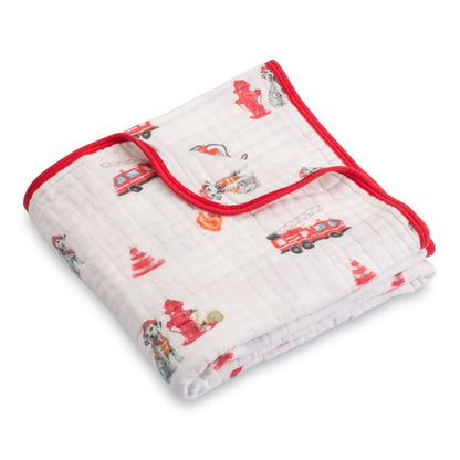 Folded baby blanket with fire truck and firefighter pattern on a white background