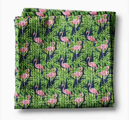 Folded fabric with pink flamingo and green leaf pattern on a white background