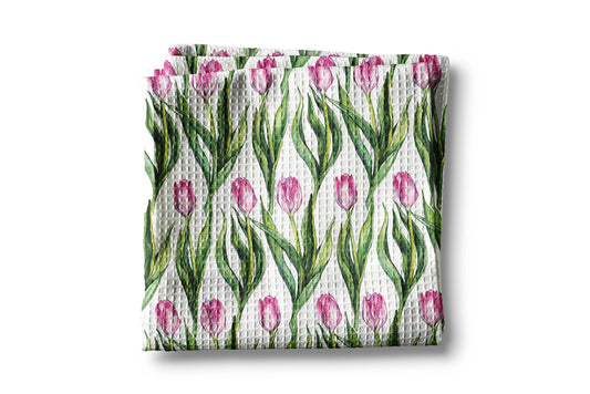Waffle-textured towel with pink tulip pattern on a white background