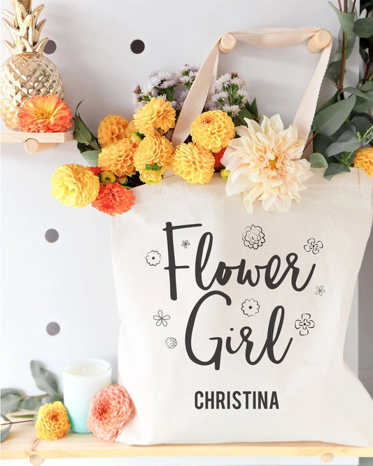 Tote bag with 'Flower Girl Christina' text, surrounded by flowers and decor.