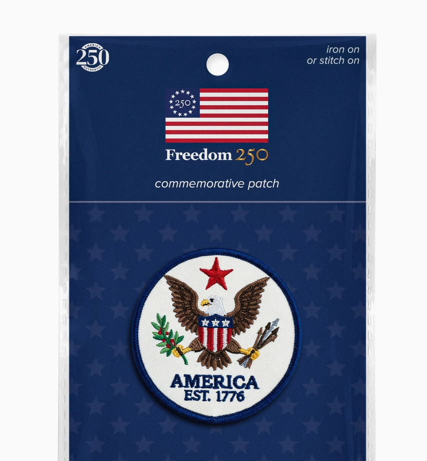 Packaged commemorative patch with American flag and eagle design on a blue background.