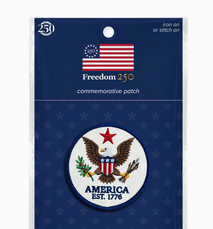 Packaged commemorative patch with American flag and eagle design on a blue background.