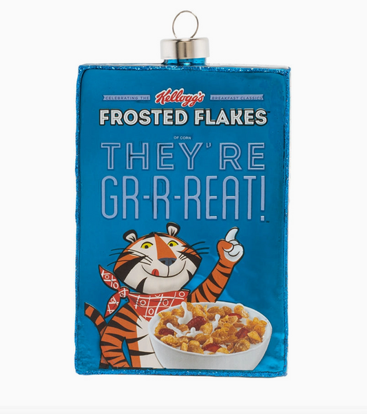 A Kellogg's Frosted Flakes cereal box Christmas ornament featuring the blue packaging, the slogan 'THEY'RE GR-R-REAT!', the cartoon cereal mascot, and a bowl of cereal, with a silver hanging loop at the top.
