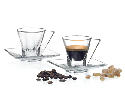 Two glass espresso cups with saucers, coffee beans, and sugar on a white background