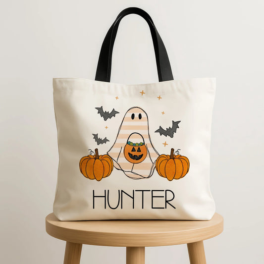 Tote bag with Halloween design featuring a ghost, pumpkins, and bats on a white background.