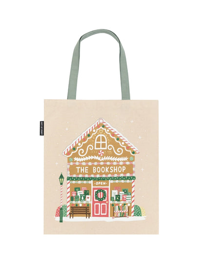 Tote bag with a gingerbread house design labeled 'The Bookshop' on a beige background