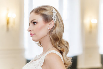 Woman with styled hair and a bridal hair clip in an elegant setting