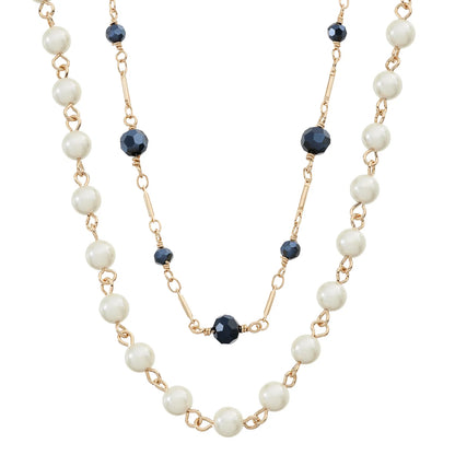A double-strand necklace featuring white faux pearl beads and gold-tone chain links, accented with faceted dark blue beads.