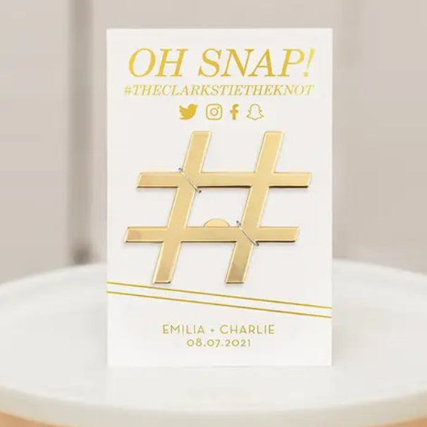 Card with gold '#' symbol and text on a white stand against a neutral background