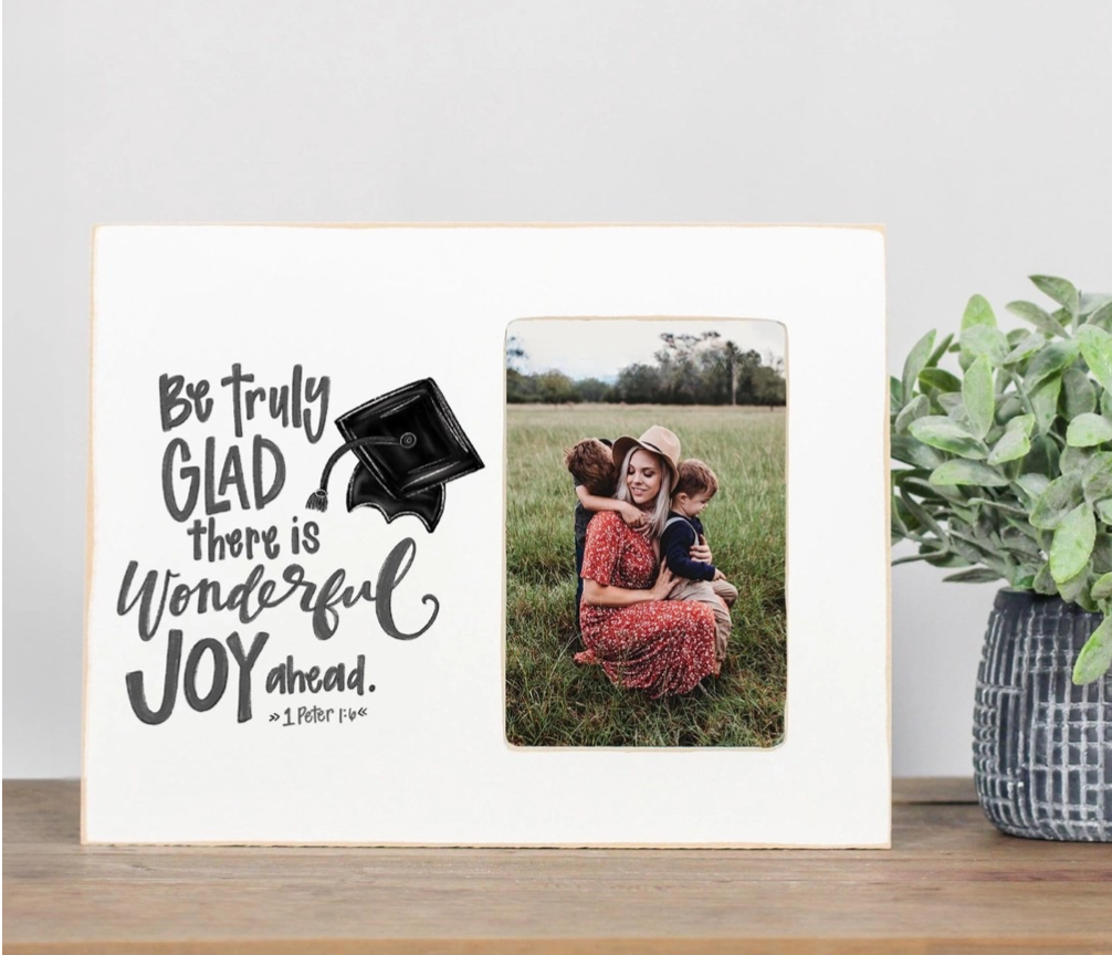 Decorative sign with motivational quote and photo of a family in a field