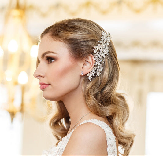 Woman with elegant hairpiece and earrings in a softly blurred indoor setting