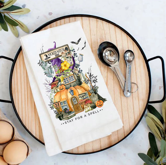 Halloween-themed kitchen towel on a wooden board with measuring spoons and eggs.