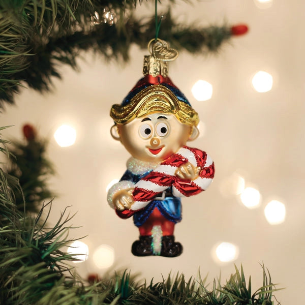Christmas ornament of a elf holding a candy cane on a decorated tree with lights.