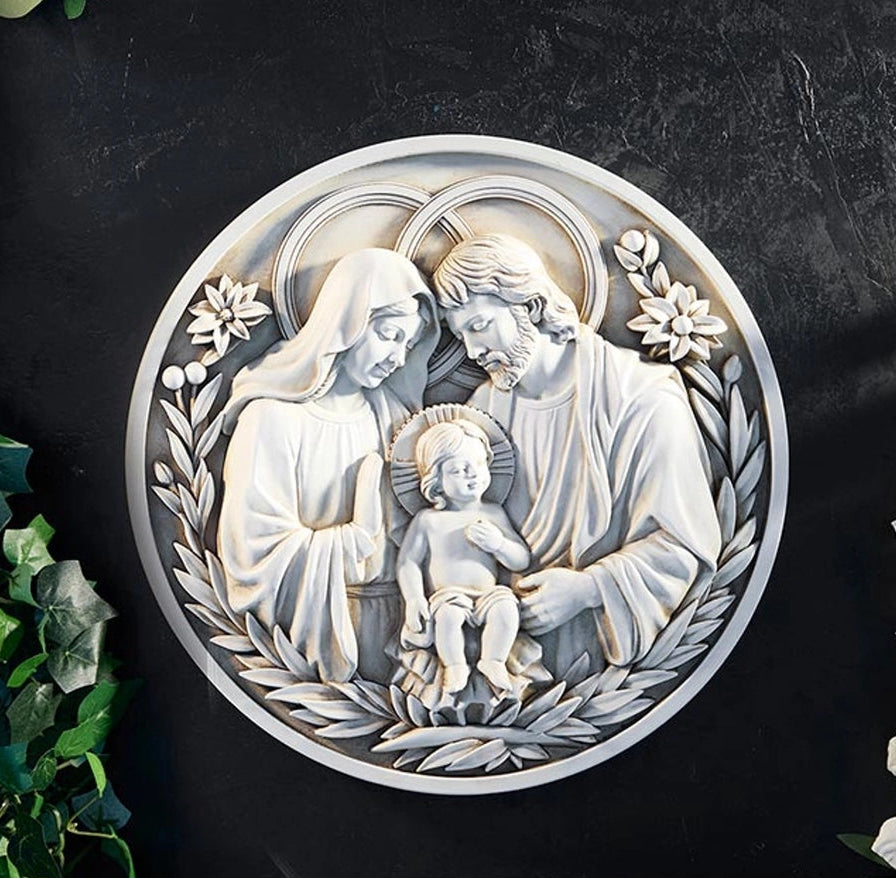 Decorative wall art of the Holy Family with floral elements on a dark background